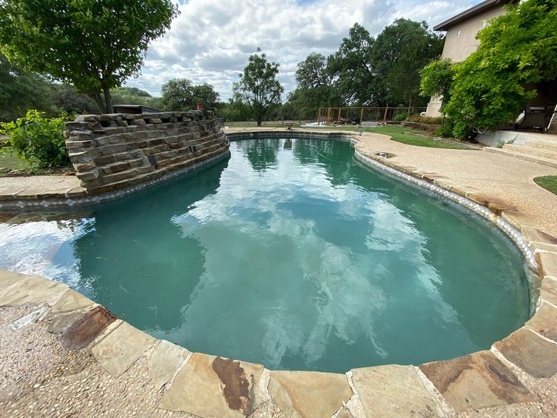 A freeform pool edged with natural stone coping