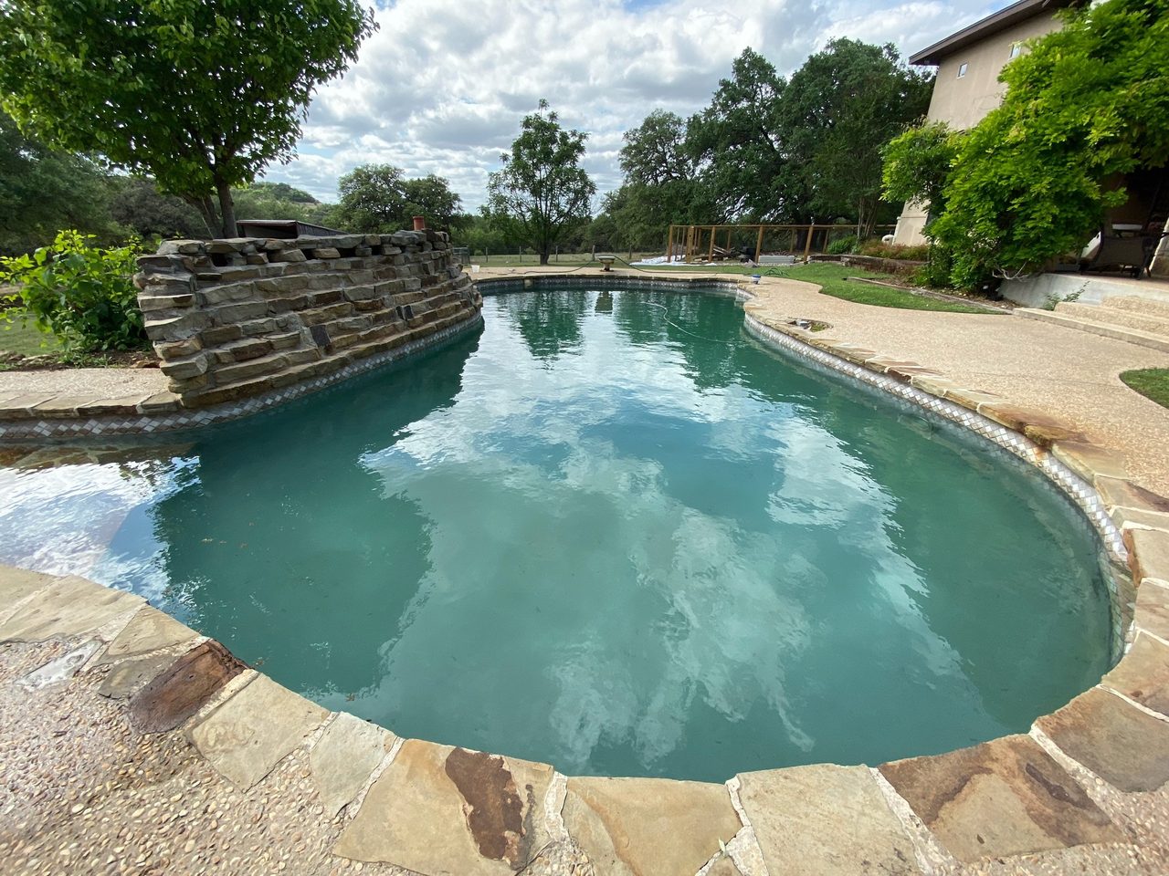 A freeform pool edged with natural stone coping