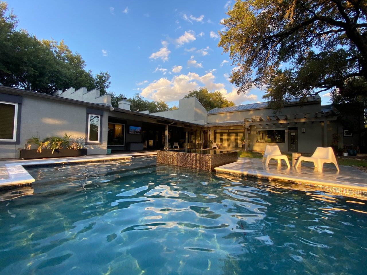 A modern pool with a tiled raised wall feature and clear water